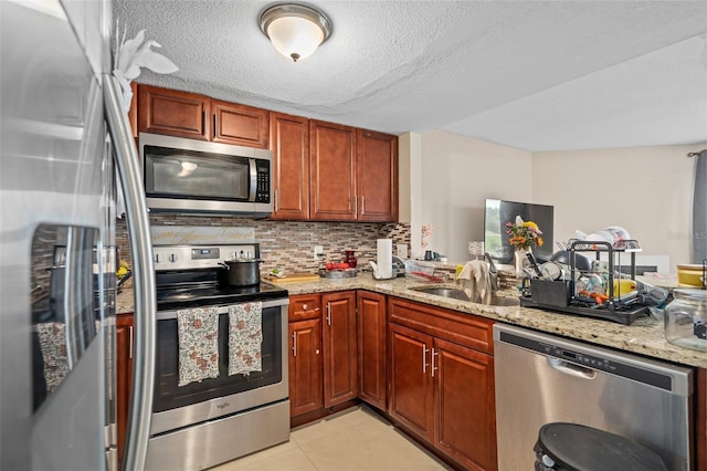 214 Majors Ln Unit B, Kissimmee, FL 34743 - kitchen with stainless steel appliances, a sink, decorative backsplash, light stone counters, and a peninsula