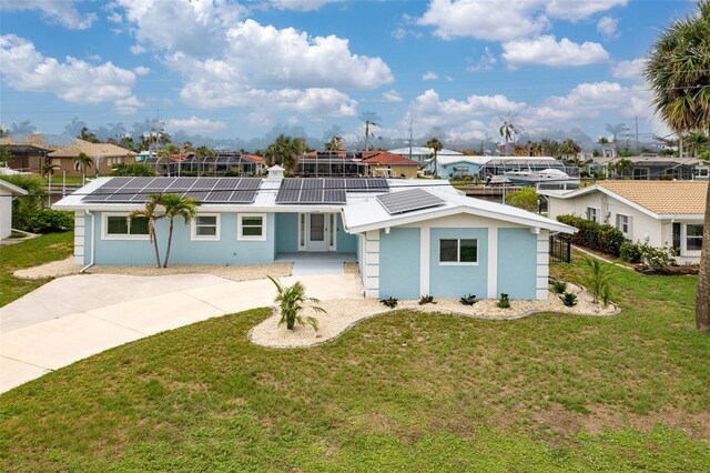 1764 Boca Raton Ct, Punta Gorda, FL 33950 - view of front of property with a residential view, a front lawn, roof mounted solar panels, and stucco siding