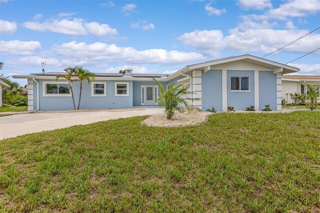 1764 Boca Raton Ct, Punta Gorda, FL 33950 - ranch-style house featuring stucco siding, roof mounted solar panels, and a front yard