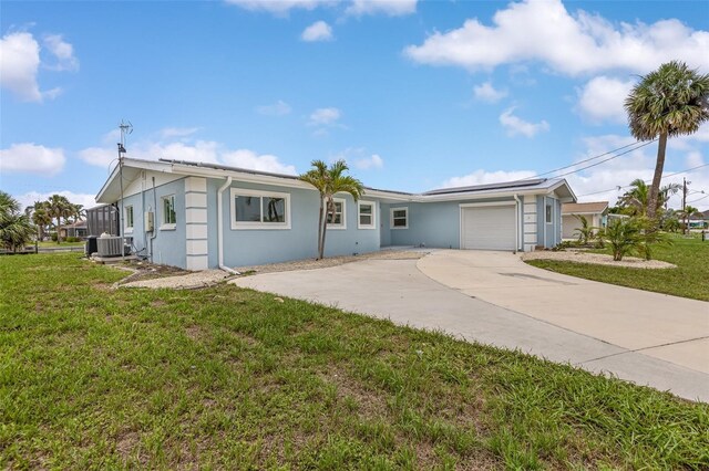 1764 Boca Raton Ct, Punta Gorda, FL 33950 - single story home with roof mounted solar panels, an attached garage, stucco siding, and a front lawn