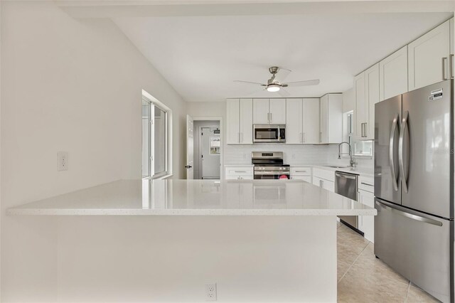 1764 Boca Raton Ct, Punta Gorda, FL 33950 - kitchen featuring stainless steel appliances, a sink, a peninsula, backsplash, and a ceiling fan