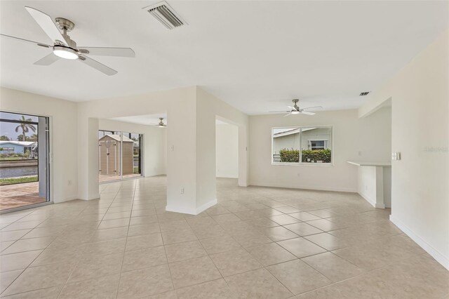 1764 Boca Raton Ct, Punta Gorda, FL 33950 - unfurnished living room featuring ceiling fan, light tile patterned flooring, and baseboards