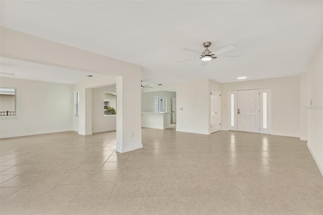 1764 Boca Raton Ct, Punta Gorda, FL 33950 - unfurnished living room with ceiling fan, light tile patterned floors, and baseboards
