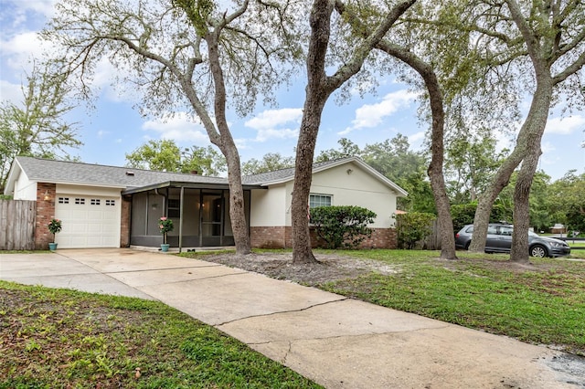 407 Ventura Dr, Sanford, FL 32773 - ranch-style house featuring a sunroom, brick siding, concrete driveway, and an attached garage