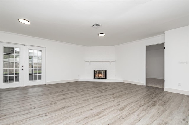 407 Ventura Dr, Sanford, FL 32773 - unfurnished living room featuring wood finished floors, french doors, ornamental molding, a fireplace, and baseboards
