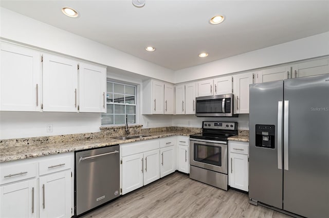 407 Ventura Dr, Sanford, FL 32773 - kitchen featuring appliances with stainless steel finishes, a sink, white cabinets, light wood-type flooring, and recessed lighting