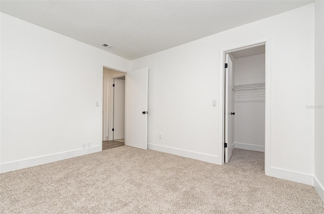 407 Ventura Dr, Sanford, FL 32773 - unfurnished bedroom featuring carpet flooring, baseboards, a textured ceiling, a walk in closet, and a closet