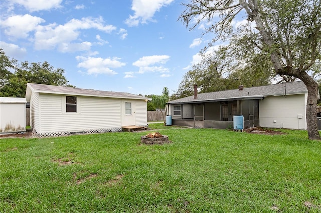 407 Ventura Dr, Sanford, FL 32773 - back of property featuring a sunroom, a fire pit, an outdoor structure, and central AC