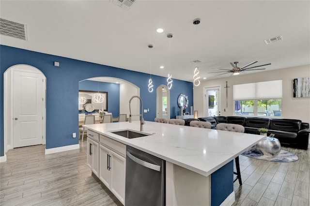2390 Standing Rock Cir, Oakland, FL 34787 - kitchen with stainless steel dishwasher, arched walkways, ceiling fan, light wood finished floors, and recessed lighting