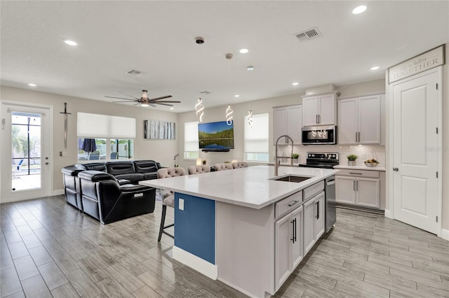 2390 Standing Rock Cir, Oakland, FL 34787 - kitchen with stainless steel microwave, recessed lighting, light countertops, light wood-style floors, and open floor plan