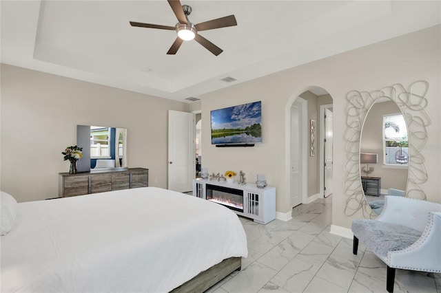 2390 Standing Rock Cir, Oakland, FL 34787 - bedroom with a tray ceiling, multiple windows, and arched walkways