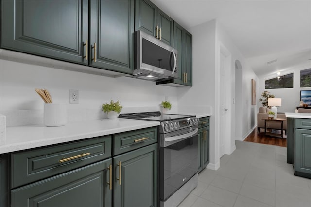 15038 Willow Ln, Tavares, FL 32778 - kitchen with appliances with stainless steel finishes, light countertops, arched walkways, and green cabinets