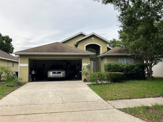 11236 Rouse Run Cir, Orlando, FL 32817 - view of front facade featuring stucco siding, a garage, driveway, roof with shingles, and a front yard