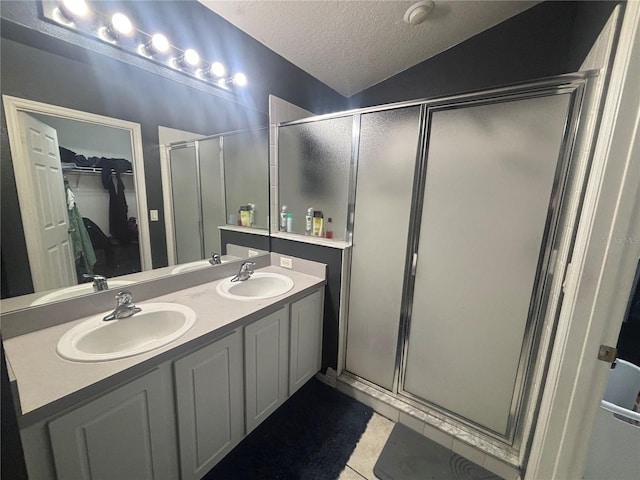 11236 Rouse Run Cir, Orlando, FL 32817 - bathroom with a shower stall, a walk in closet, double vanity, a textured ceiling, and tile patterned flooring
