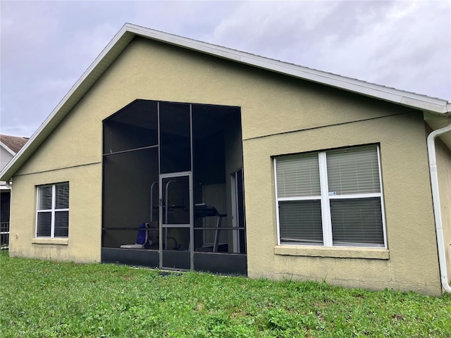 11236 Rouse Run Cir, Orlando, FL 32817 - rear view of property featuring stucco siding, a yard, and a sunroom