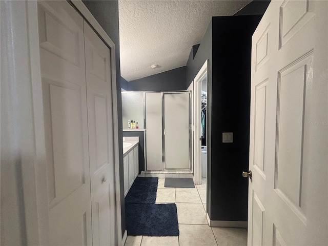 11236 Rouse Run Cir, Orlando, FL 32817 - full bathroom featuring a shower stall, a textured ceiling, tile patterned floors, vanity, and vaulted ceiling