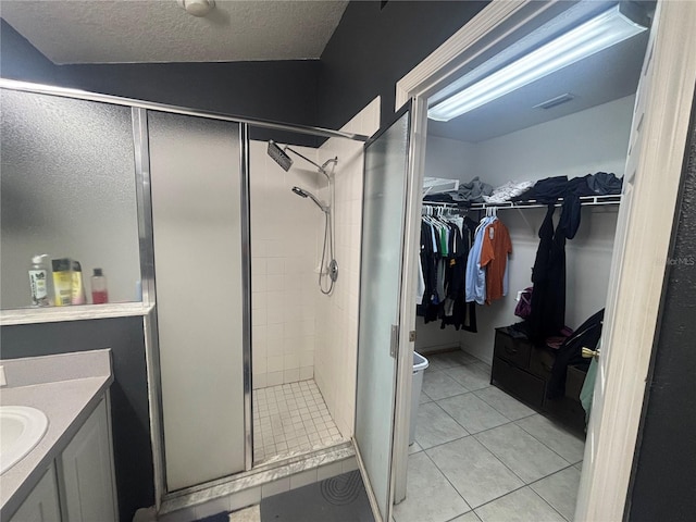 11236 Rouse Run Cir, Orlando, FL 32817 - full bath featuring a shower stall, vanity, a spacious closet, tile patterned floors, and a textured ceiling
