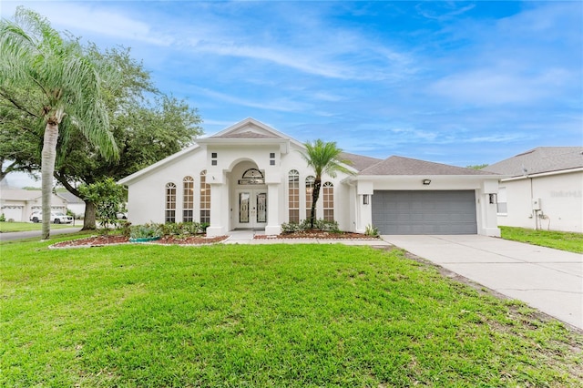 10001 Newington Dr, Orlando, FL 32836 - view of front of home with french doors, a garage, driveway, a front lawn, and stucco siding
