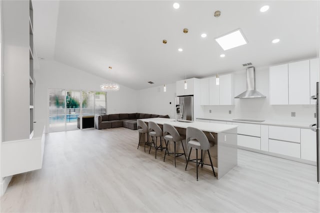 10001 Newington Dr, Orlando, FL 32836 - kitchen featuring wall chimney exhaust hood, modern cabinets, stainless steel fridge with ice dispenser, black electric cooktop, and a kitchen breakfast bar