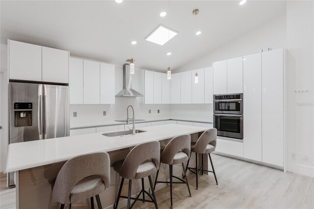 10001 Newington Dr, Orlando, FL 32836 - kitchen featuring wall chimney exhaust hood, stainless steel appliances, a sink, a skylight, and hanging light fixtures