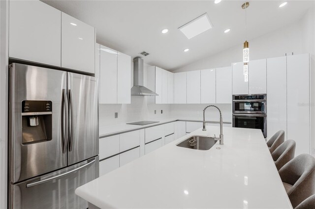 10001 Newington Dr, Orlando, FL 32836 - kitchen with appliances with stainless steel finishes, wall chimney range hood, a sink, a kitchen bar, and pendant lighting
