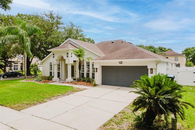 10001 Newington Dr, Orlando, FL 32836 - mediterranean / spanish home with an attached garage, stucco siding, roof with shingles, and driveway