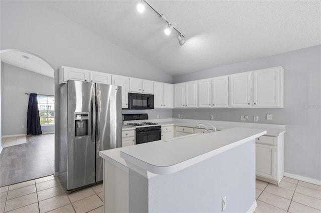 631 Lady Diana Dr, Davenport, FL 33837 - kitchen with white range with gas cooktop, stainless steel refrigerator with ice dispenser, black microwave, lofted ceiling, and arched walkways