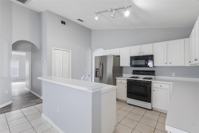 631 Lady Diana Dr, Davenport, FL 33837 - kitchen featuring black microwave, gas stove, stainless steel fridge, high vaulted ceiling, and light tile patterned flooring
