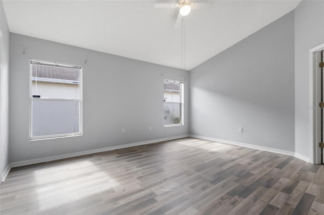 631 Lady Diana Dr, Davenport, FL 33837 - empty room featuring a ceiling fan, vaulted ceiling, wood finished floors, and baseboards