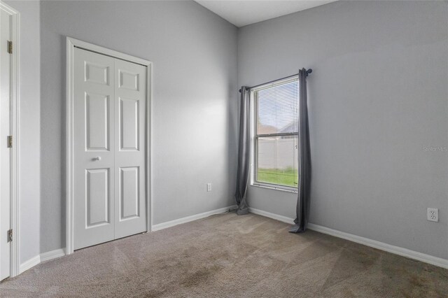 631 Lady Diana Dr, Davenport, FL 33837 - unfurnished bedroom with carpet, a closet, and baseboards