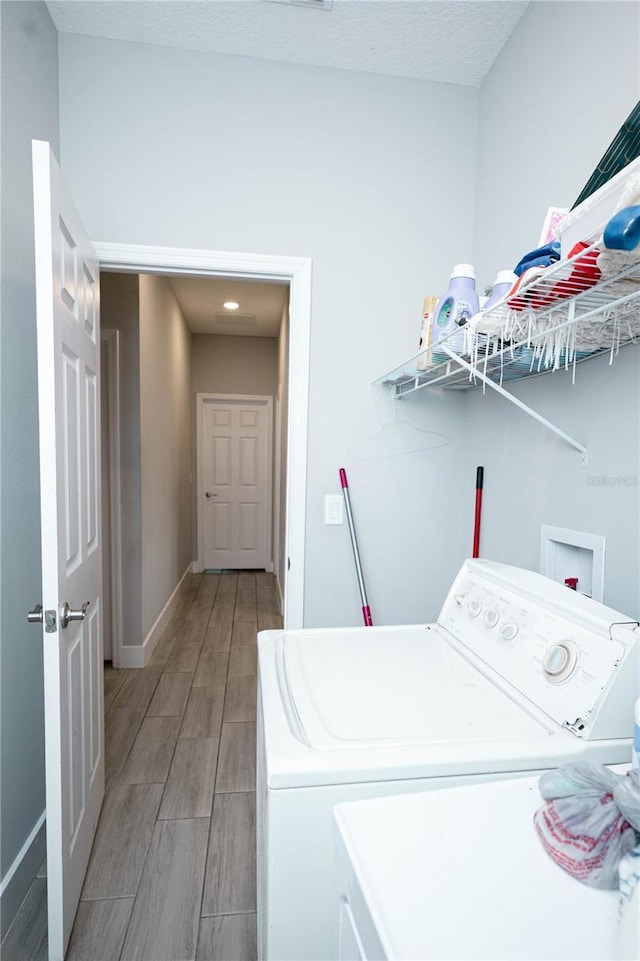 309 E 13th St, Apopka, FL 32703 - laundry room with light wood-type flooring, washing machine and clothes dryer, and baseboards