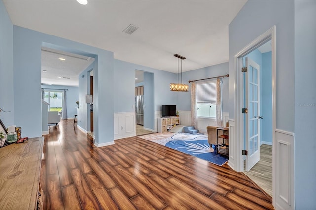 11616 Thacker Dr, Clermont, FL 34711 - unfurnished living room with wood finished floors, a wainscoted wall, a chandelier, and recessed lighting