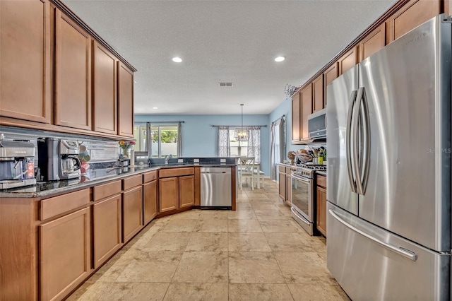 11616 Thacker Dr, Clermont, FL 34711 - kitchen with stainless steel appliances, a peninsula, recessed lighting, brown cabinetry, and backsplash