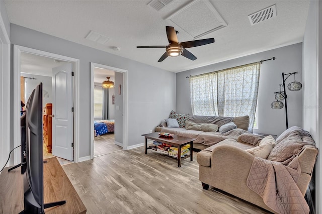 11616 Thacker Dr, Clermont, FL 34711 - living room with light wood-style flooring, a textured ceiling, and a ceiling fan