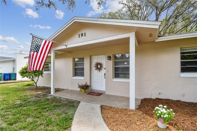 191 Ruskin St, Lake Mary, FL 32746 - view of exterior entry with stucco siding and a yard