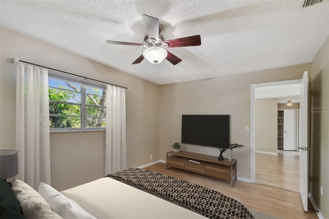 191 Ruskin St, Lake Mary, FL 32746 - bedroom featuring light wood-type flooring, a textured ceiling, and a ceiling fan