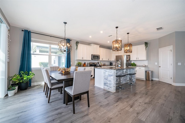 3943 Crawley Down Loop, Sanford, FL 32773 - dining area with a chandelier, wood finished floors, and baseboards