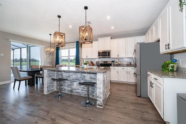 3943 Crawley Down Loop, Sanford, FL 32773 - kitchen featuring appliances with stainless steel finishes, a chandelier, tasteful backsplash, stone countertops, and recessed lighting