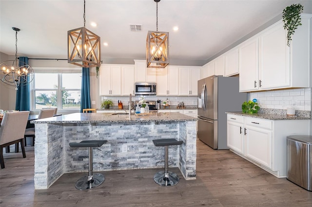 3943 Crawley Down Loop, Sanford, FL 32773 - kitchen with appliances with stainless steel finishes, a chandelier, stone countertops, decorative backsplash, and recessed lighting