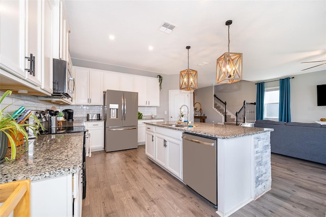 3943 Crawley Down Loop, Sanford, FL 32773 - kitchen featuring appliances with stainless steel finishes, a sink, open floor plan, tasteful backsplash, and a chandelier