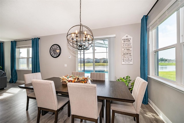 3943 Crawley Down Loop, Sanford, FL 32773 - dining area featuring wood finished floors, a chandelier, baseboards, and a water view
