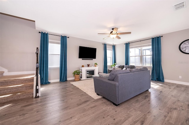 3943 Crawley Down Loop, Sanford, FL 32773 - living area featuring ceiling fan, wood finished floors, baseboards, and a glass covered fireplace