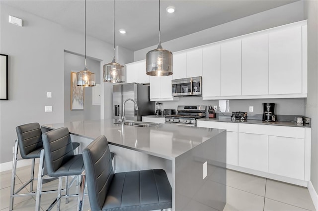 7740 Sandy Ridge Dr Unit 124, Reunion, FL 34747 - kitchen with appliances with stainless steel finishes, a sink, white cabinetry, a breakfast bar, and a kitchen island with sink