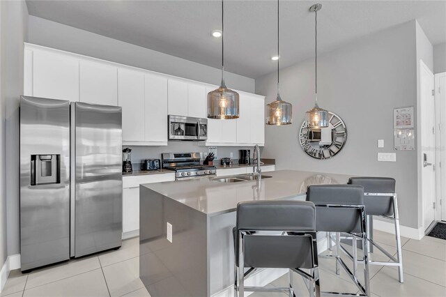 7740 Sandy Ridge Dr Unit 124, Reunion, FL 34747 - kitchen featuring stainless steel appliances, a sink, light tile patterned flooring, white cabinetry, and a kitchen island with sink