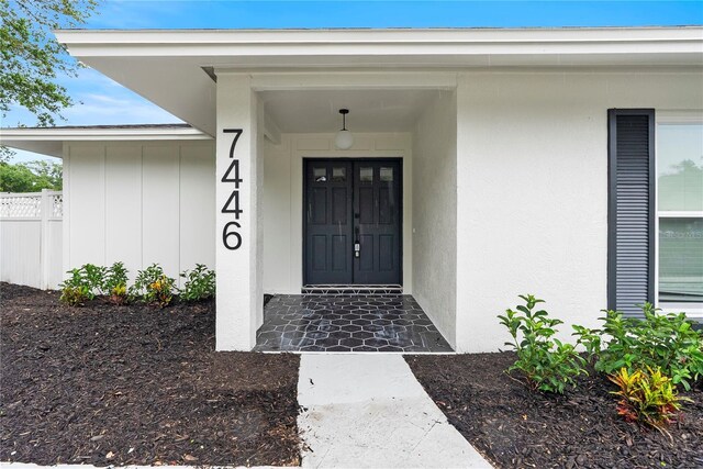 7446 Houston Ct E, Winter Park, FL 32792 - view of exterior entry featuring board and batten siding and stucco siding