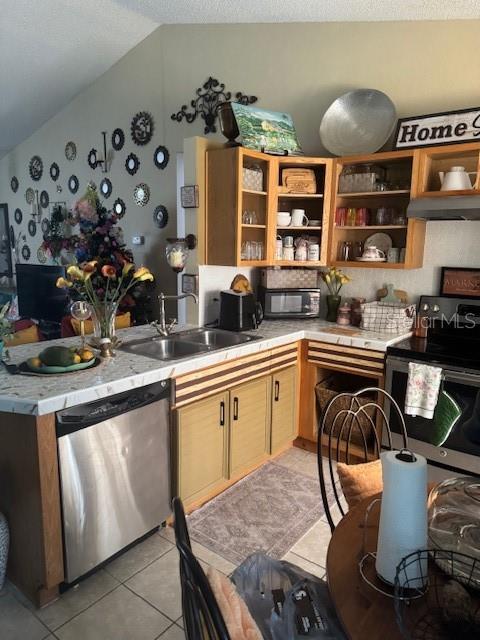1907 Myakka Ct, Poinciana, FL 34759 - kitchen with stainless steel appliances, a sink, lofted ceiling, light tile patterned flooring, and light countertops