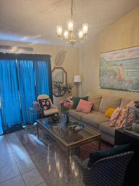 1907 Myakka Ct, Poinciana, FL 34759 - living area featuring tile patterned flooring, a chandelier, and a textured ceiling