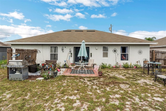 1907 Myakka Ct, Poinciana, FL 34759 - back of property with stucco siding, roof with shingles, and a patio area