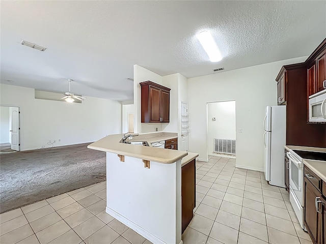 36730 Oconee Ave, Eustis, FL 32736 - kitchen with white appliances, light tile patterned flooring, light colored carpet, light countertops, and open floor plan