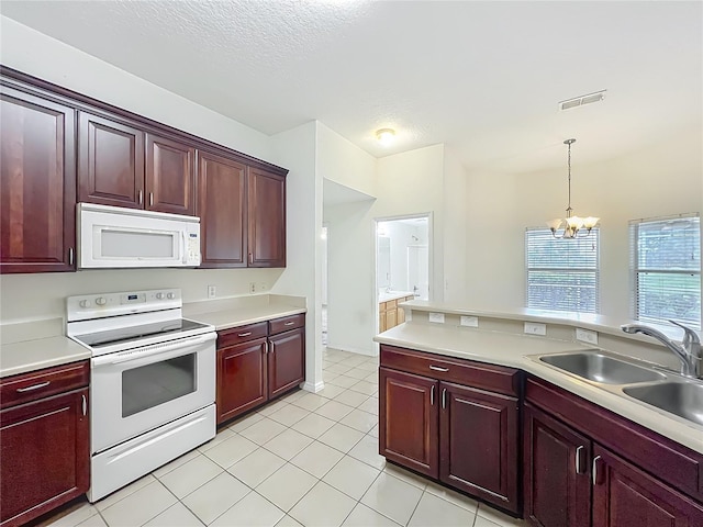 36730 Oconee Ave, Eustis, FL 32736 - kitchen featuring white appliances, reddish brown cabinets, a chandelier, pendant lighting, and a textured ceiling